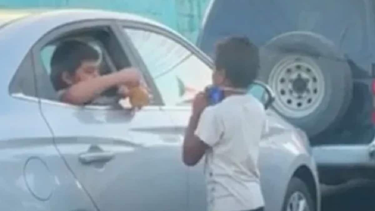 Ambos niños juegan sin prejuicios en un semáforo en el que el pequeño limpiaparabrisas busca el sustento diario.